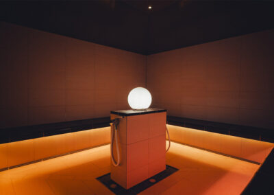 Dampfbad mit LED-Beleuchtung, zentrales Dampfmodul mit Kugellampe, komplett gefliest – moderner Spa-Raum für Aromatherapie oder Dampfanwendungen.