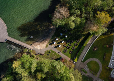 Blick von oben auf die Hotelanlage mit See und Bootssteg.
