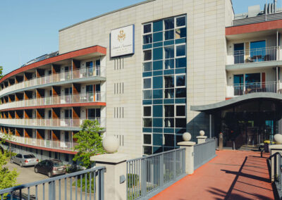 Blick auf die Hotelfassade mit Schild "Hotel Fleesensee". Barrierefreier Eingang zu sehen.