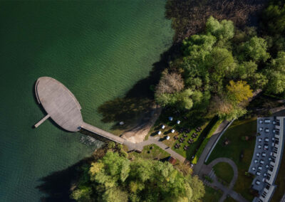 Blick von oben auf die Hotelanlage mit See und Bootssteg.