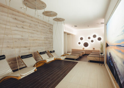 Hängeliegen aus Holz und heller Wandvertäfelung – natürliche Materialien für ein beruhigendes Raumgefühl.