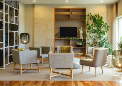 Medienraum mit mehreren grauen Sesseln und Blick ins Grüne.