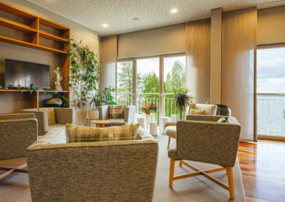 Medienraum mit mehreren grauen Sesseln und Blick ins Grüne.