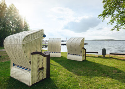 Strandkörbe im Gartenbereich mit Blick auf den See.